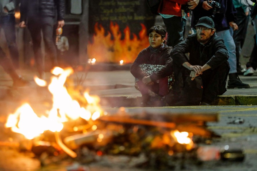 Apoiadores da nova Constituição sentados perto de fogueira após resultado: Carta foi percebida como radical por maioria da população