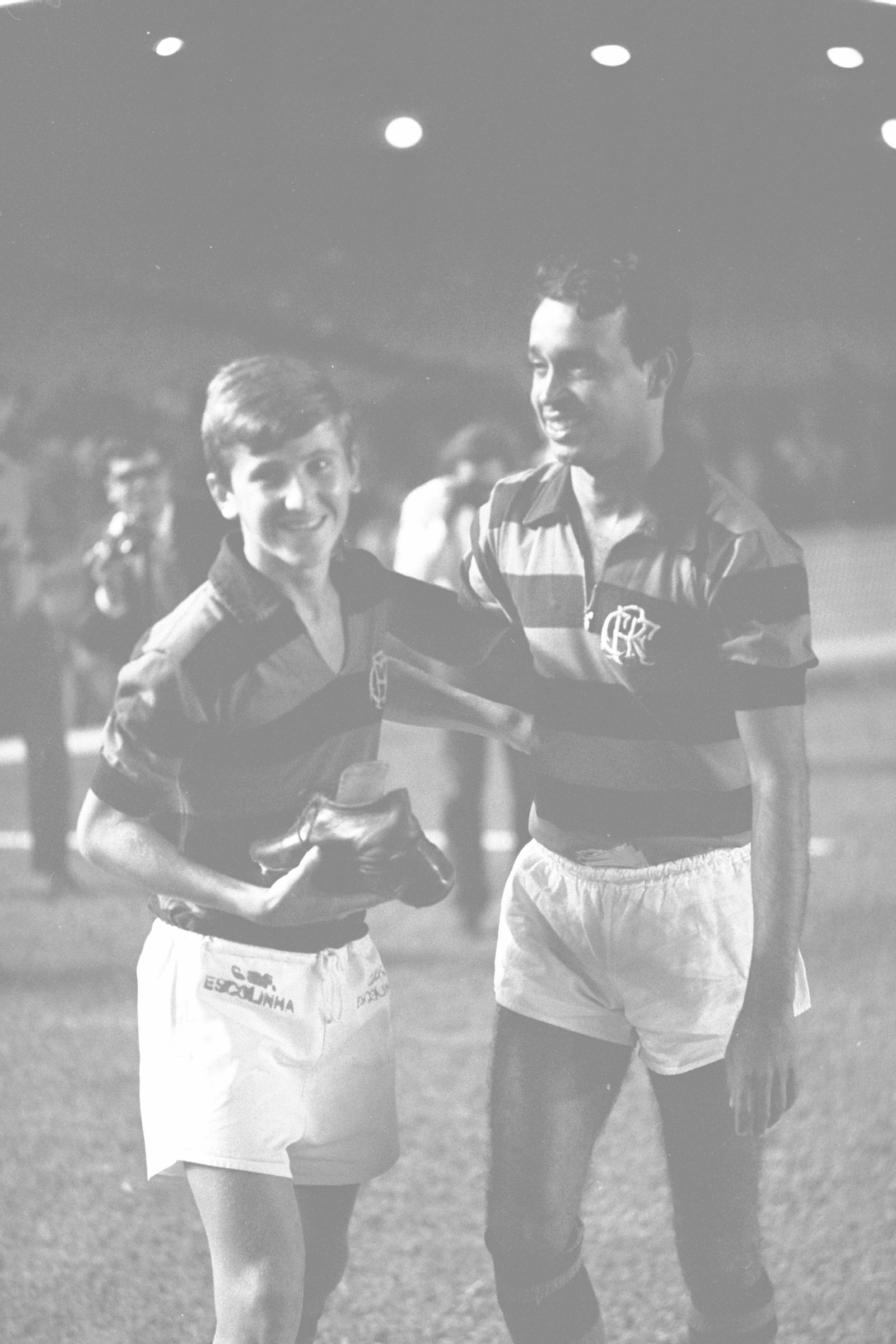 Em uma das cenas mais famosas da história do Flamengo, Carlinhos, o Violino, dá suas chuteiras à Zico, que assumiria sua camisa 10 — Foto: Agência O Globo