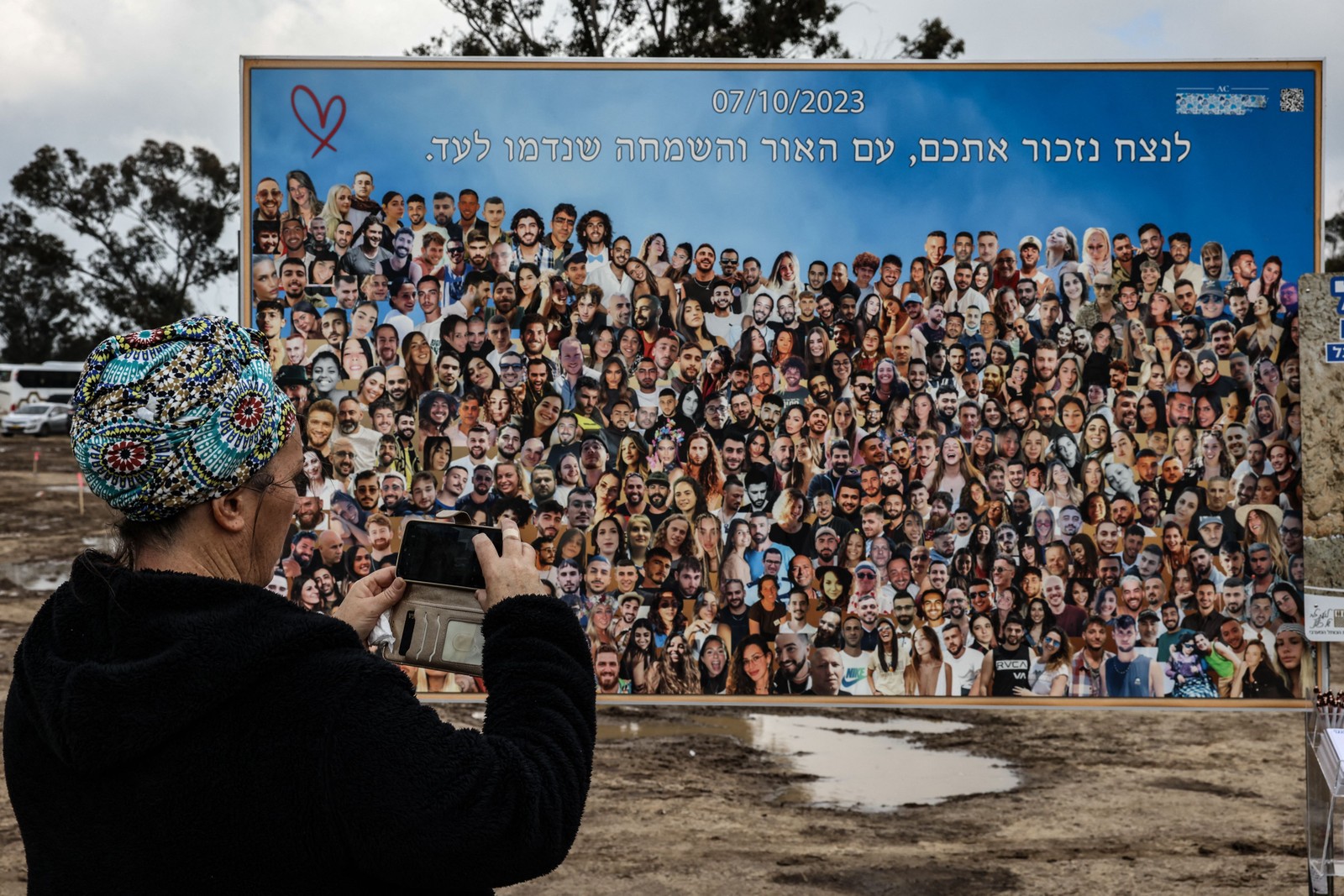 Um mosaico gigante, composto por fotos das vítimas com a mensagem "Lembraremos de vocês pela eternidade", recebe os visitantes no estacionamento de Reim. — Foto: RONALDO SCHEMIDT / AFP