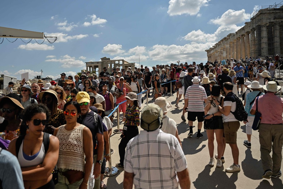 Turistas esperam sob o sol para entrar na Acrópole, em Atenas — Foto: Louisa Gouliamaki/AFP