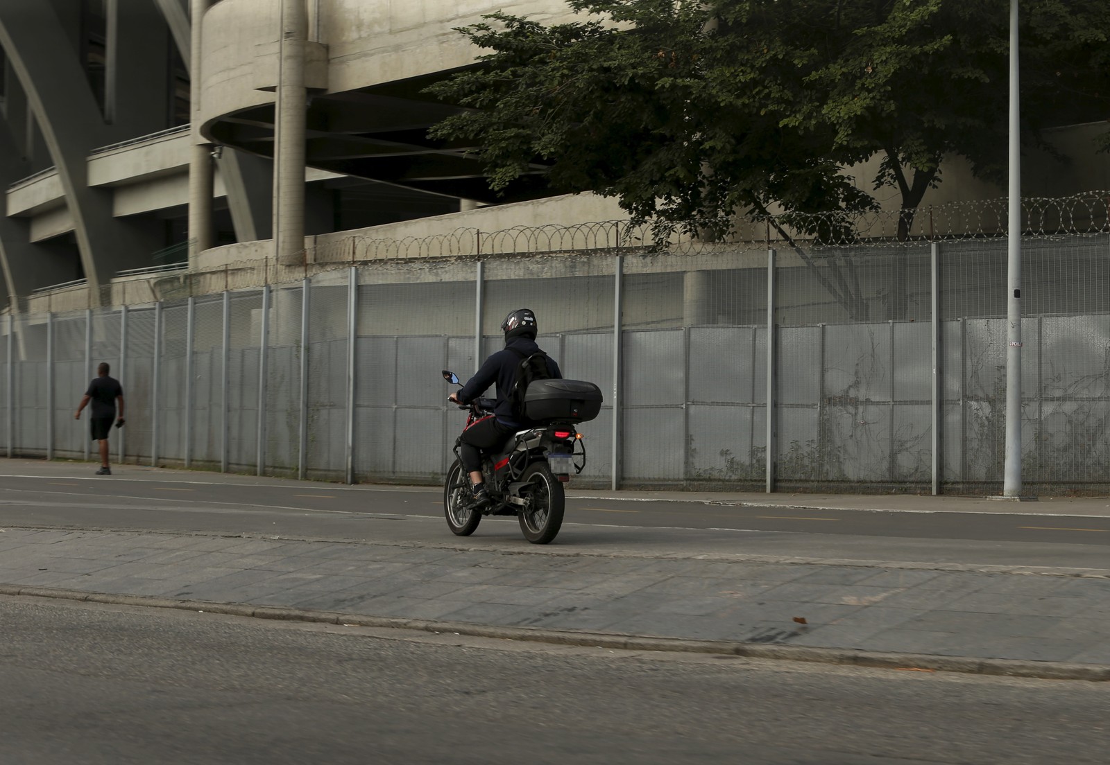 Um motociclista passa pela calçada em frente ao estádio do Maracanã — Foto: Fabiano Rocha / Agência O Globo