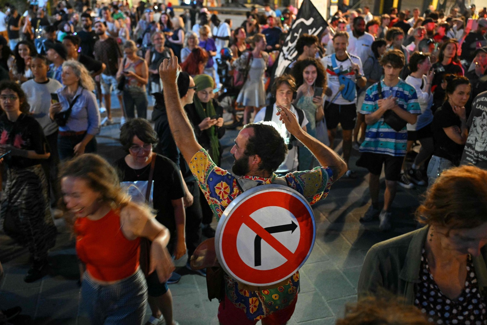Manifestantes comemoram com placa 'proibido virar à direita' — Foto: Nicolas Tucat/AFP