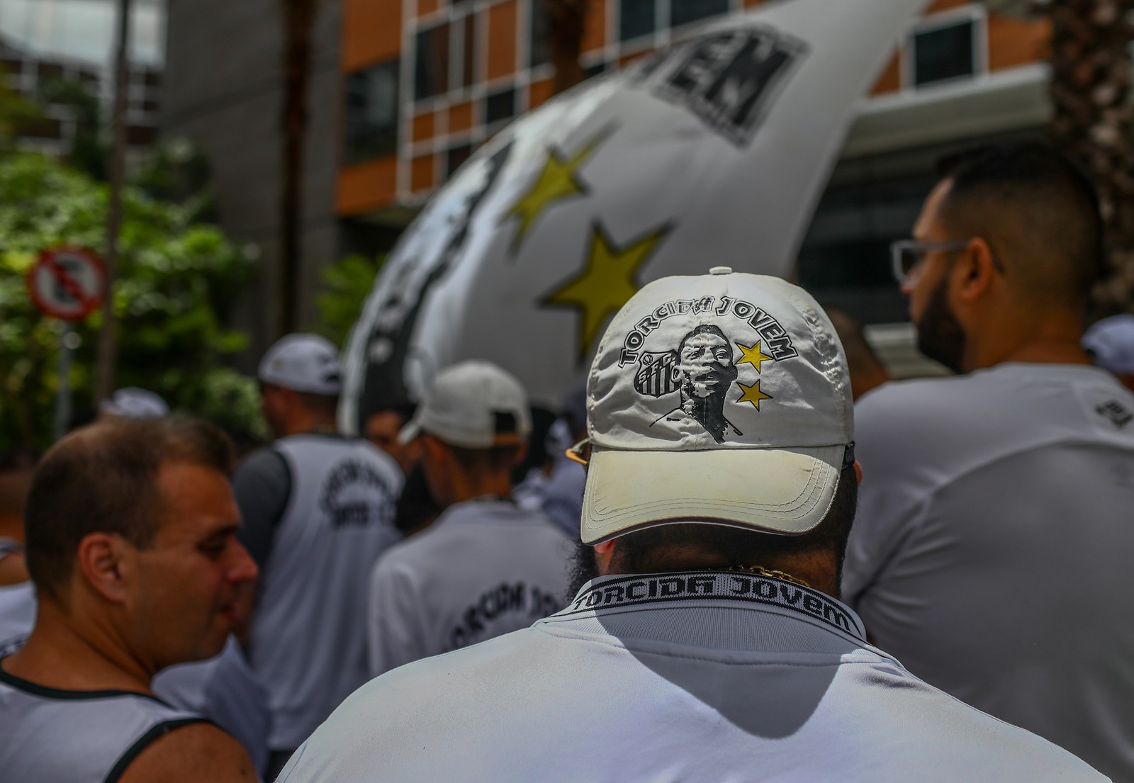 Durante vigília para Pelé na porta do Hospital Albert Einstein, torcedores do Santos levaram camisas, bandeiras e até bonés com o rosto do Rei estampado — Foto: Felipe Iruatã/Zimel Press/Agência O Globo