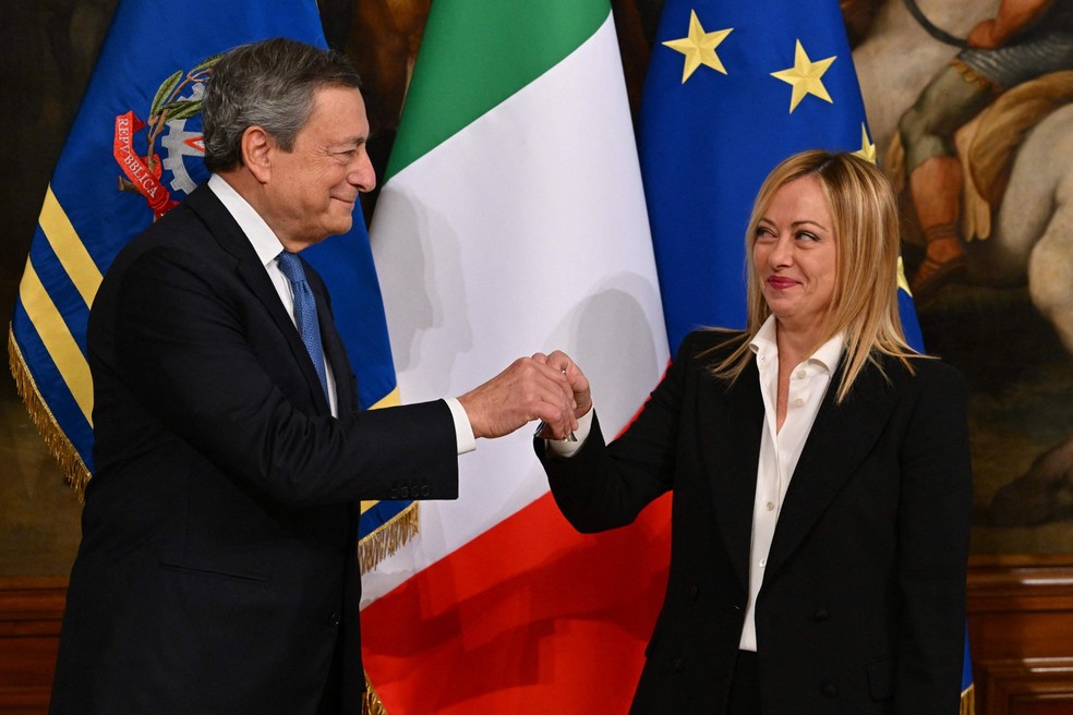 O ex-primeiro-ministro da Itália, Mario Draghi, entrega o sino do ministro à nova primeira-ministra, Giorgia Meloni, durante uma cerimônia no Palácio Chigi, em Roma — Foto: Andreas Solaro / AFP