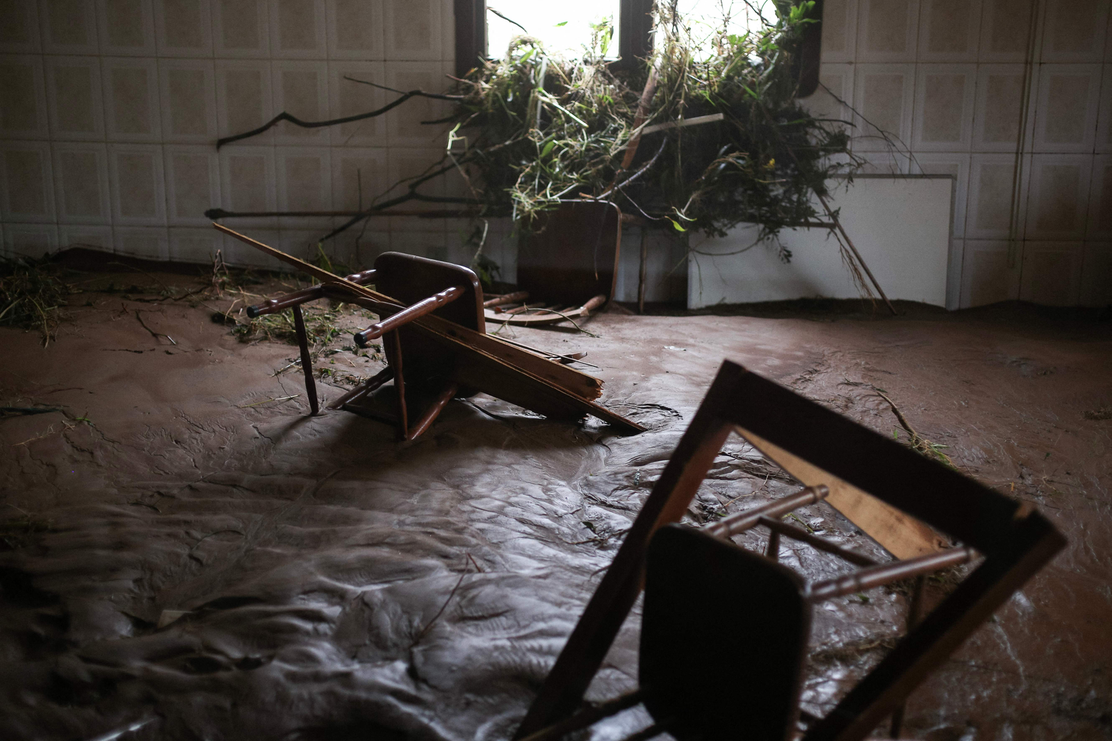 Cadeiras em meio a lama e detritos dentro de uma casa parcialmente destruída pelas fortes chuvas em Sinimbu, na região do Vale do Rio Pardo, Rio Grande do Sul — Foto: Anselmo Cunha / AFP