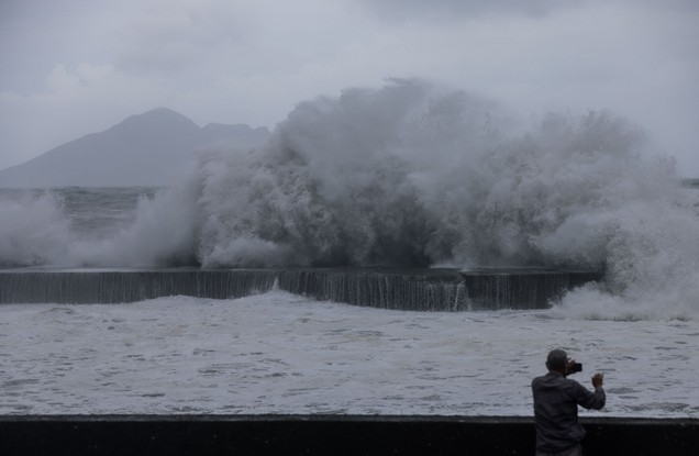 Um homem tira fotos de ondas enormes em Yilan enquanto o tufão Haikui atinge o leste de Taiwan