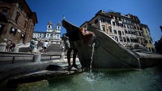 Homem se refresca na fonte Barcaccia, perto da Escadaria Espanhola, durante uma onda de calor em Roma, em 21 de agosto de 2023. — Foto: FILIPPO MONTEFORTE / AFP