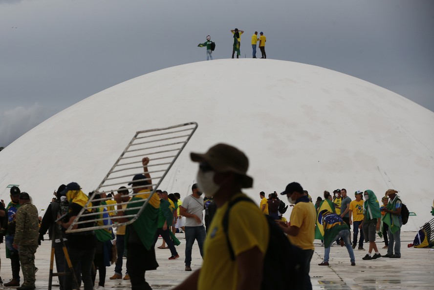 Manifestante carrega gradil no teto do Congresso Nacional durante atos golpistas promovidos por apoiadores de Jair Bolsonaro em 8 de janeiro