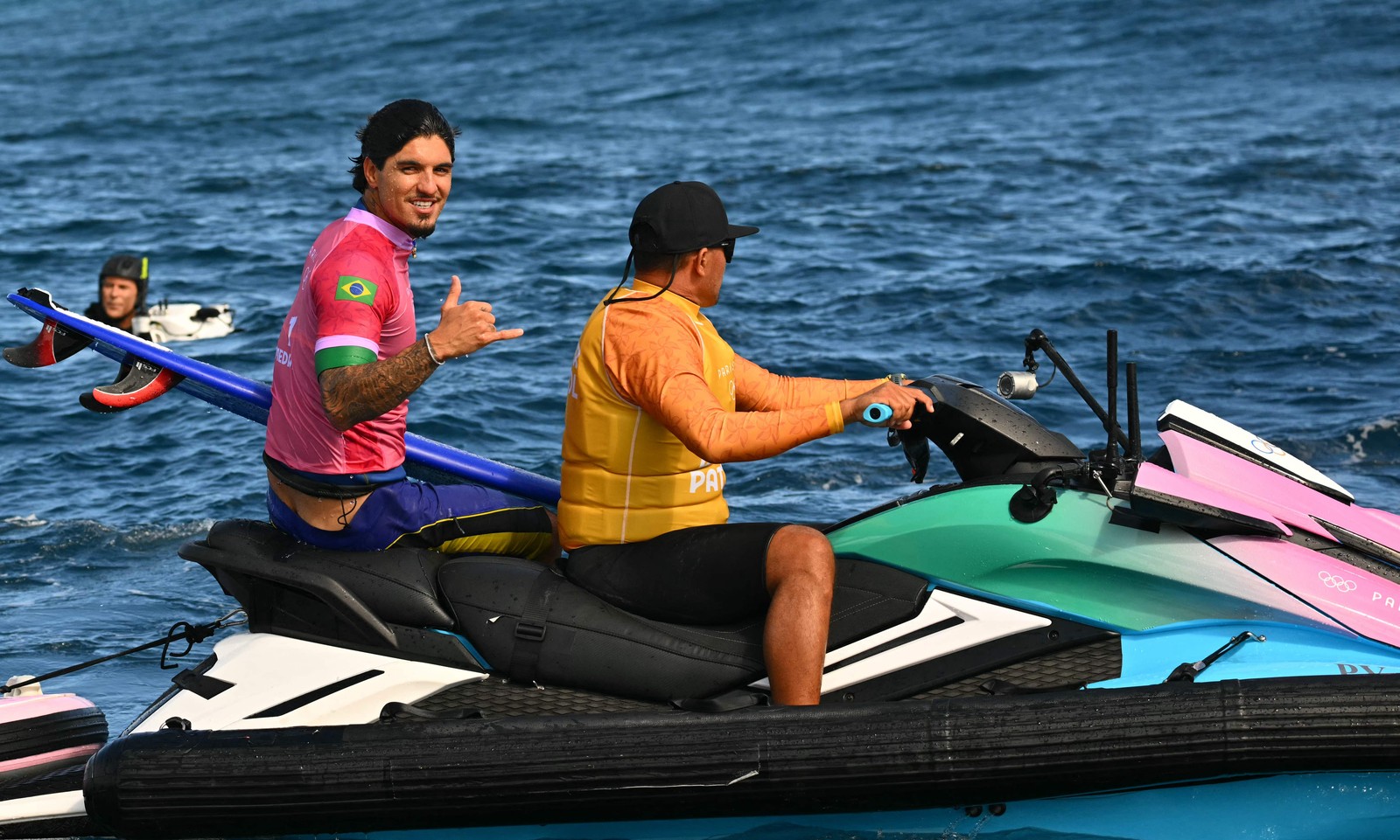 Gabriel Medina "pegando carona" em jet ski em Teahupo'o — Foto: Jerome BROUILLET / AFP