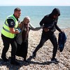 Imigrante é resgatada por agentes de segurança britânicos durante tentativa de cruzar o canal da Mancha em direção ao Reino Unido - HENRY NICHOLLS / AFP