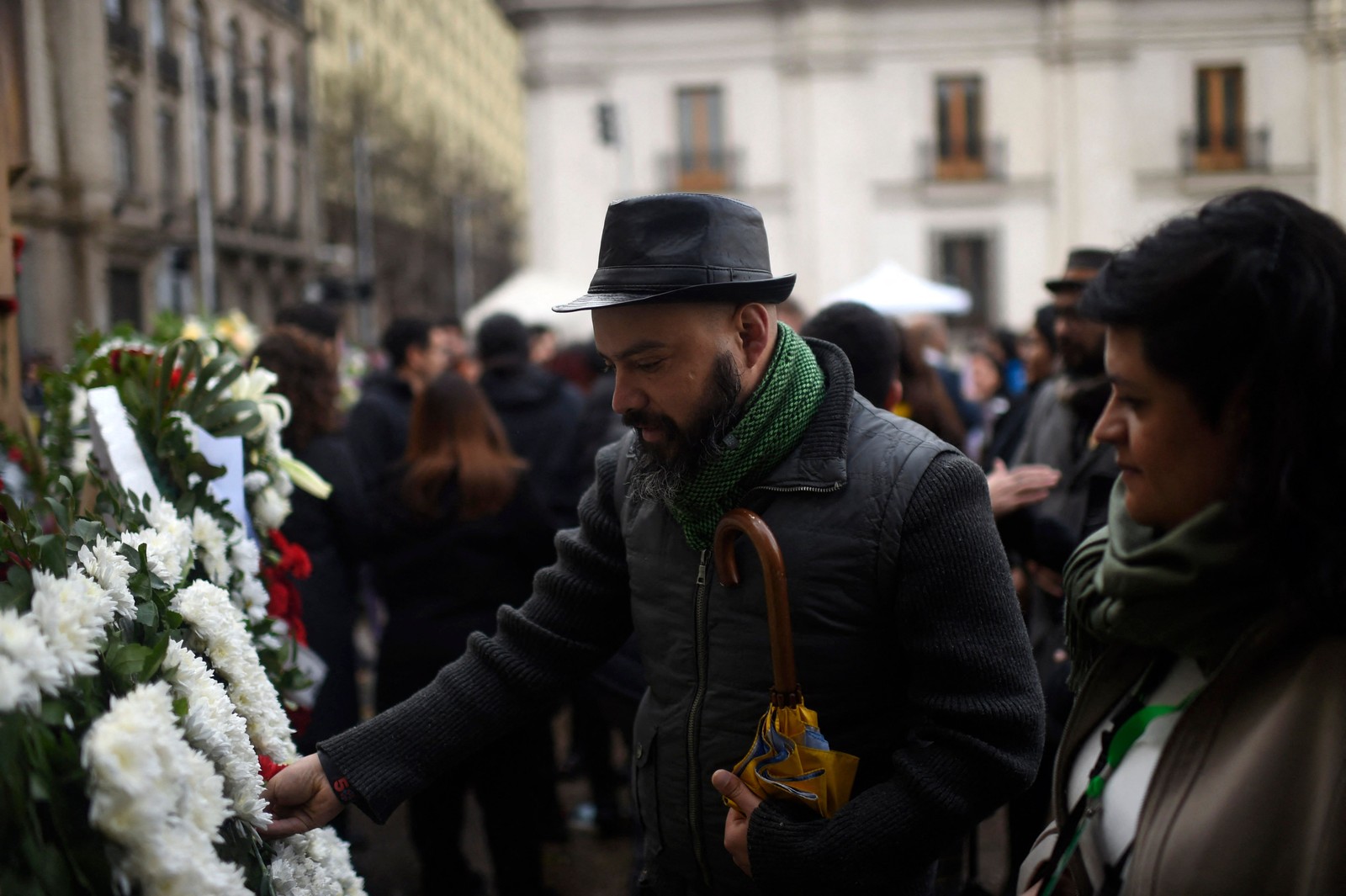 Pessoas se reúnem em frente ao Palácio Presidencial La Moneda para participar de uma cerimônia em comemoração aos 50 anos da ditadura chilena em Santiago — Foto: Pablo VERA / AFP