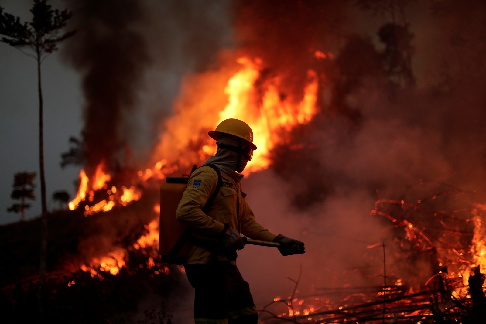 Membro da brigada de incêndio do Instituto Brasileiro do Meio Ambiente e dos Recursos Naturais Renováveis (Ibama) tenta controlar um incêndio em uma área da selva amazônica em Apuí, Estado do AmazonasREUTERS