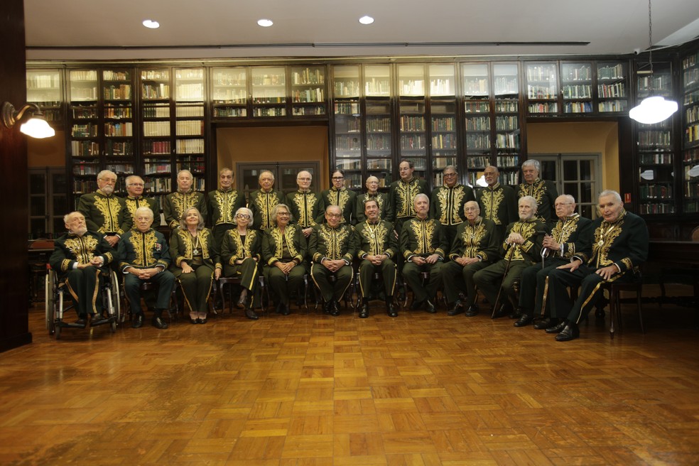 Ruy Castro (sentado, ao centro) com outros integrantes da ABL, em sua posse — Foto: Alexandre Cassiano