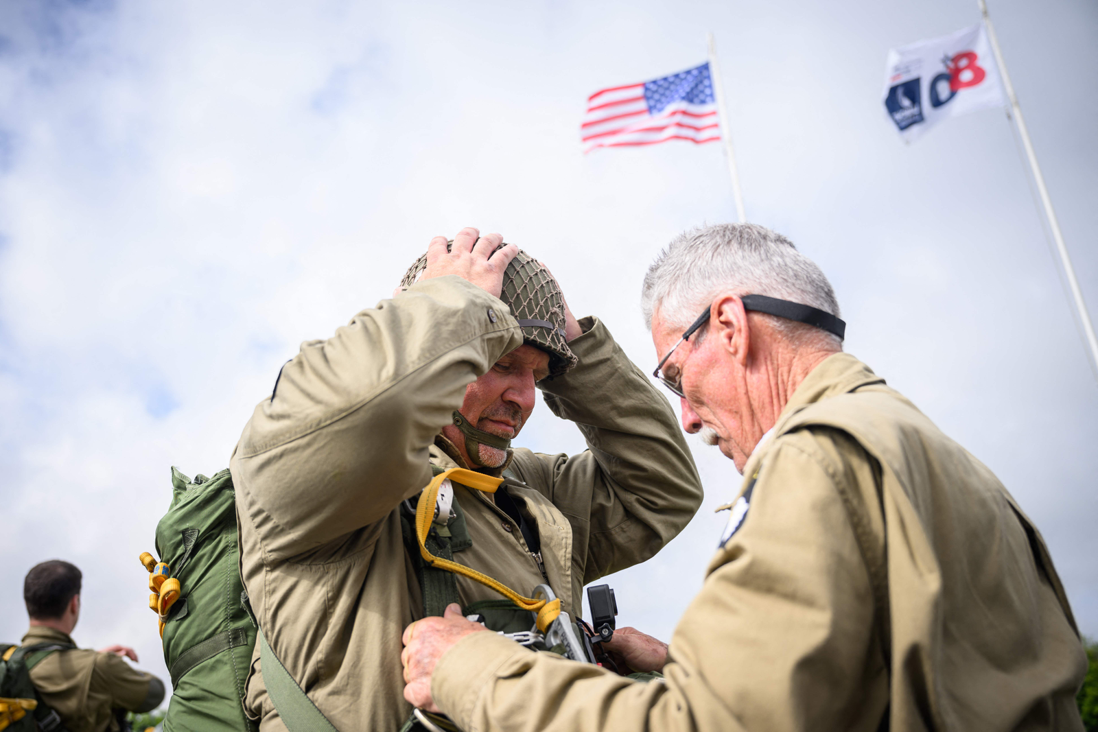 Paraquedistas vestem réplicas de trajes de paraquedistas da Segunda Guerra Mundial, estes que verificam seus equipamentos antes de saltar de uma aeronave Lockheed C-130 Hercules fretada e navegada pela tripulação dos EUA, no aeroporto de Cherbourg, antes das comemorações do "Dia D" marcando o 80º aniversário do Dia D. — Foto: LOIC VENANCE / AFP