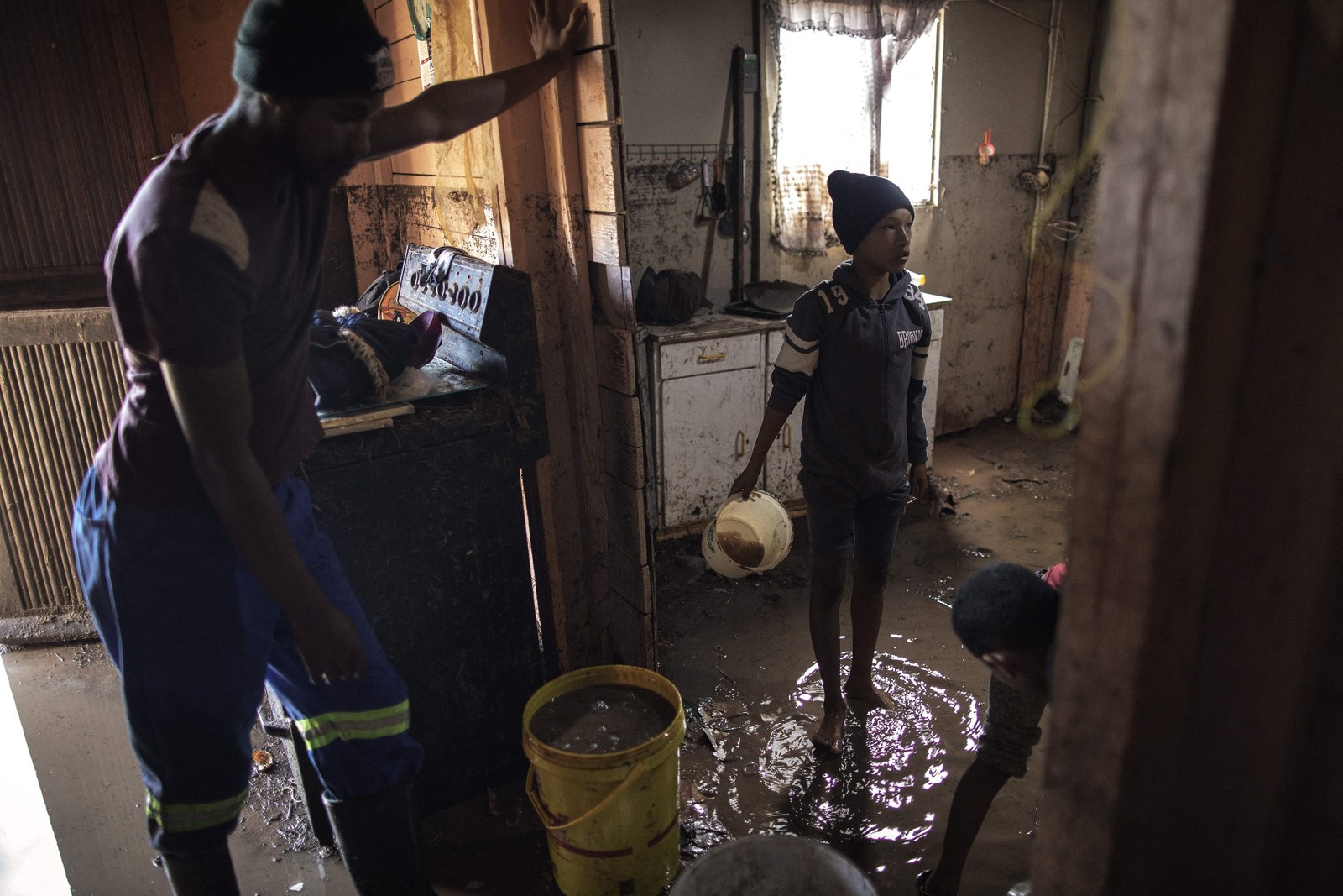 Moradores limpam as águas das enchentes de suas casas. As enchentes causadas por chuvas torrenciais e ventos fortes na costa leste da África do Sul mataram pelo menos 22 pessoas, disseram as autoridades locais na terça-feira. As inundações atingiram vários locais em duas províncias do leste, dois raros tornados foram detectados, as temperaturas caíram e a neve caiu em algumas regiões centrais. — Foto: GIANLUIGI GUERCIA/AFP