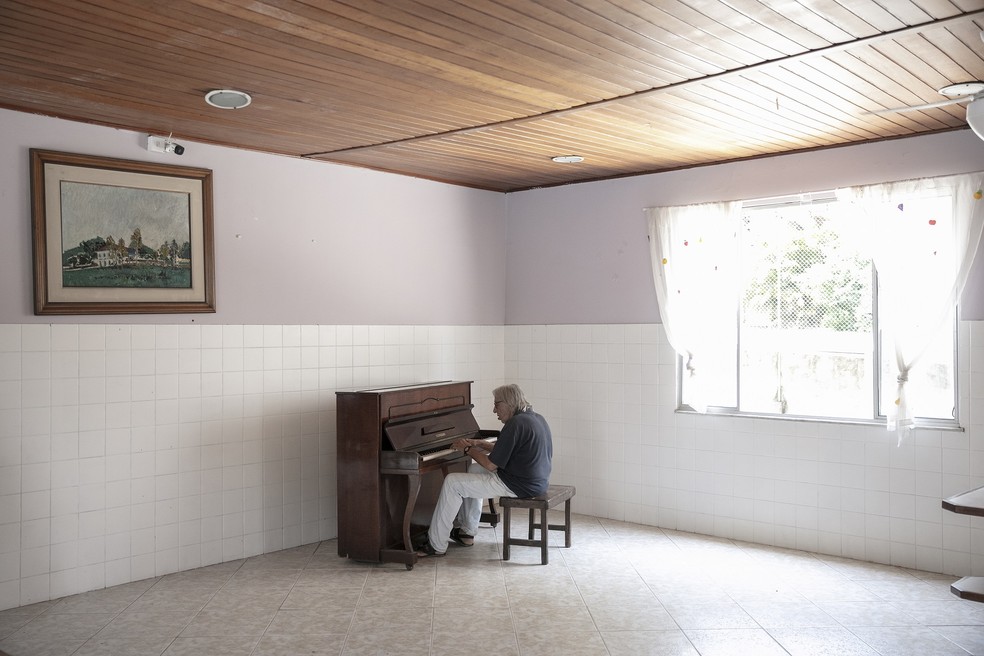 Mauro Continentino toca o piano do refeitório, que mandou afinar — Foto: LEO AVERSA
