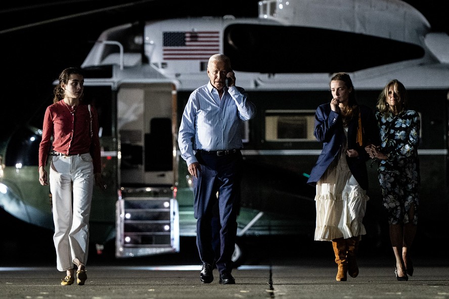 O presidente Joe Biden fala ao telefone enquanto é acompanhado pela primeira-dama, Jill, e suas netas suas netas Finnegan e Natalie Biden.