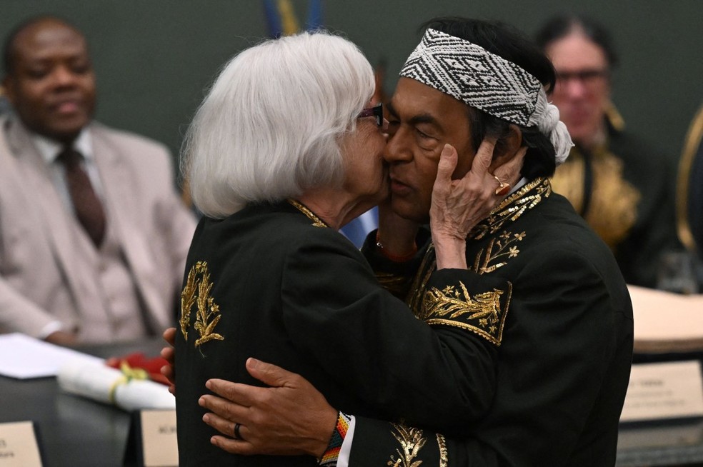 Imortais: Fernanda Montenegro abraçou e beijou o amigo Ailton Krenak antes de entregar a ele o colar de acadêmico — Foto: AFP