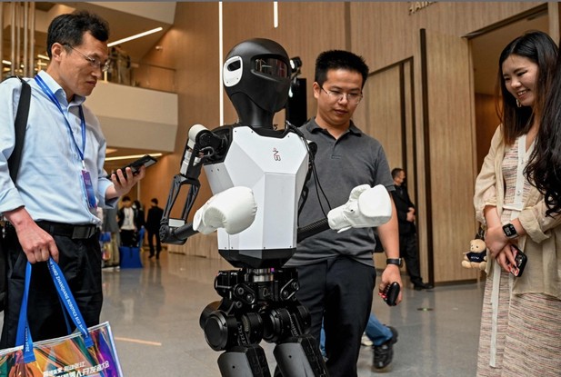 Visitantes olham para um robô humanoide na Conferência de Desenvolvedores de Robôs Humanoides da China 2024, em Xanga