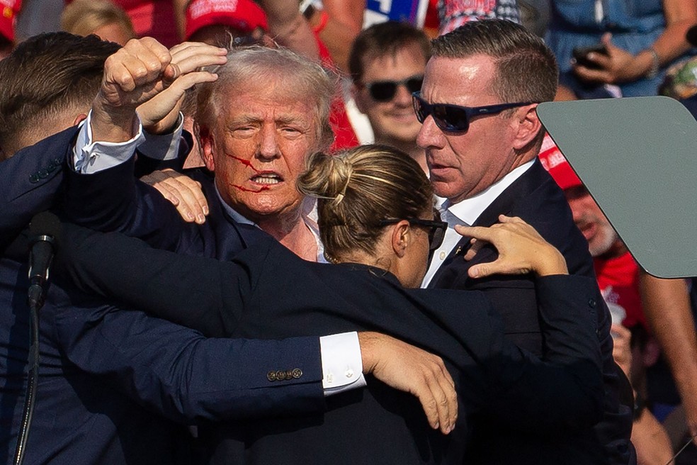 Trump ergue o punho logo após ser baleado durante comício na Pensilvânia — Foto: Rebecca Droke/AFP