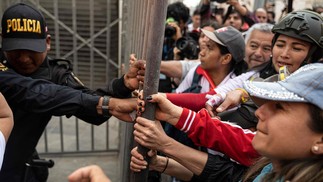 Policiais tentam conter opositores do presidente peruano Pedro Castillo durante manifestação para exigir sua renúncia, em Lima, em novembro. — Foto: Ernesto BENAVIDES / AFP