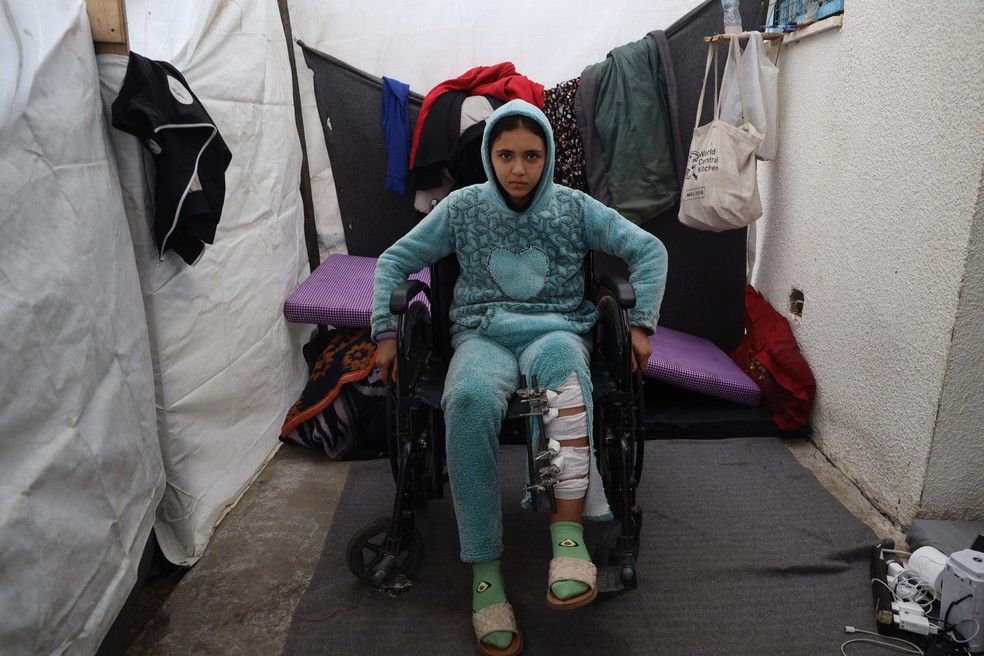 Mays, de 13 anos, sentada numa cadeira de rodas devido a uma lesão na perna, em um abrigo em Khan Yunis, sul de Gaza. — Foto: © UNICEF/UNI501951/El Baba