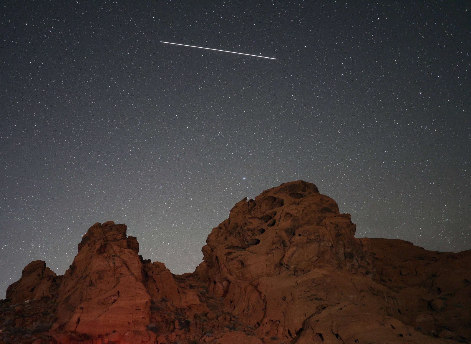 Foto com exposição de 25 segundos mostra chuva de meteoros vistas no Parque Estadual Vale do Fogo, Nevada, EUA — Foto: Ethan Miller/Getty Images/AFP