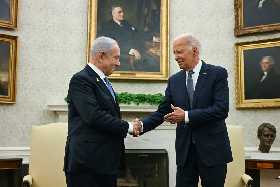 Presidente dos EUA, Joe Biden (D), aperta a mão do premier israelense, Benjamin Netanyahu, antes de reunião na Casa Branca — Foto: Jim WATSON / AFP