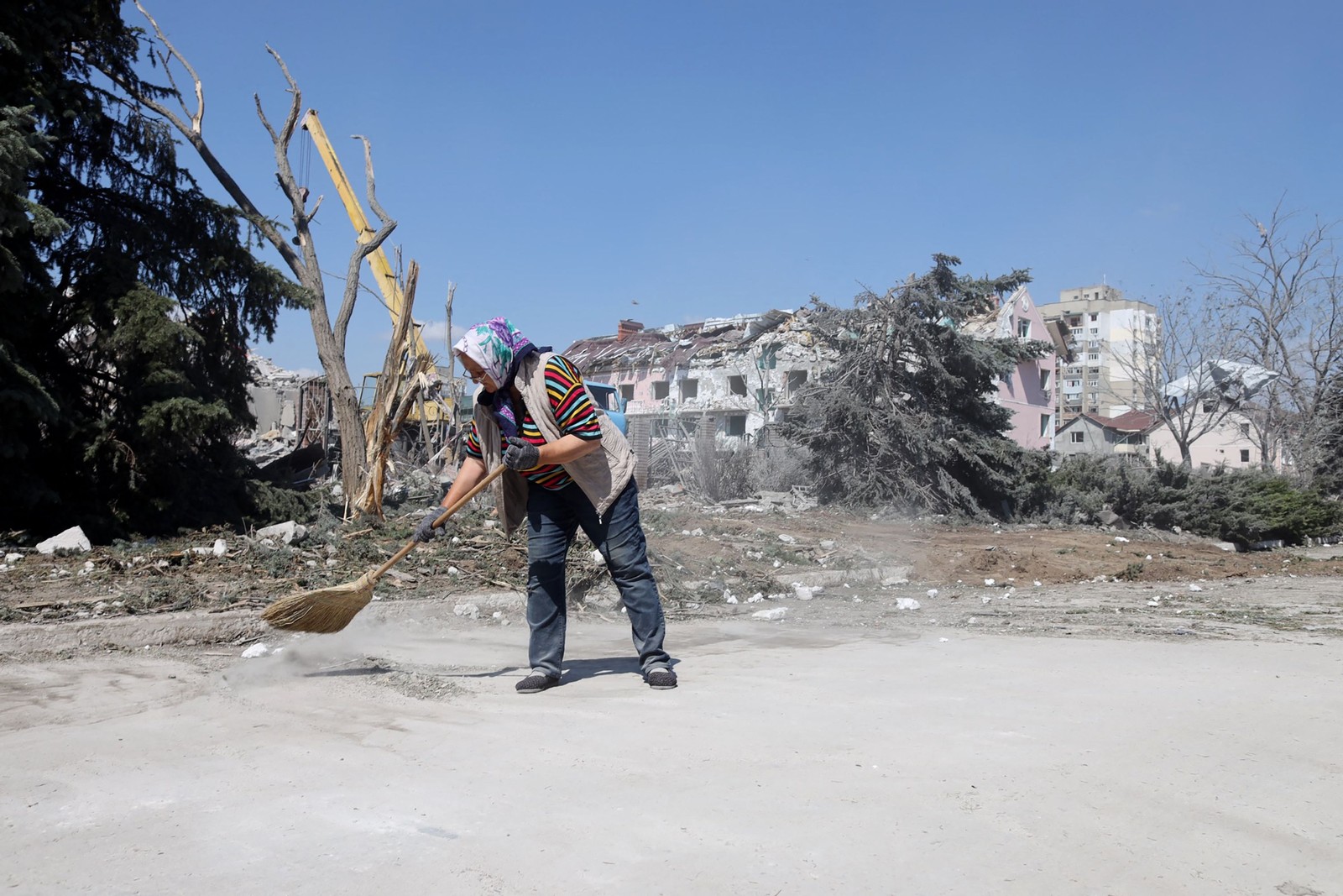 idosa limpa a área em frente a um prédio destruído por ataque com mísseis em Serhiivka, perto de Odessa — Foto: Oleksandr GIMANOV / AFP