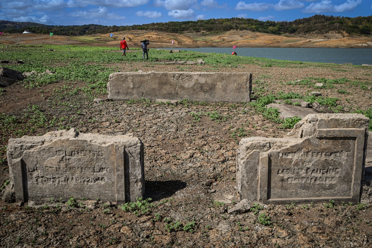 Vestígios da cidade centenária de Pantabangan ressurgiram no norte das Filipinas após o nível da água da barragem baixar em meio a uma seca que assola muitas partes do país — Foto: JAM STA ROSA / AFP