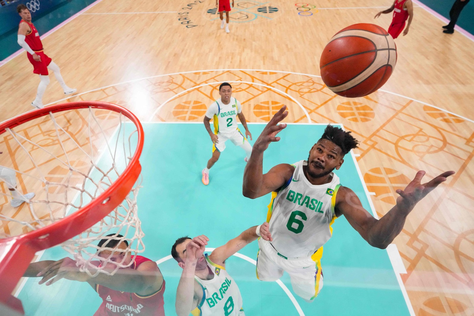 Cristiano Felício, número 06 do Brasil, tenta o rebote na partida do grupo B da fase preliminar masculina de basquete entre Brasil e Alemanha durante os Jogos Olímpicos de Paris 2024, no estádio Pierre-Mauroy em Villeneuve-d'Ascq, norte da França, em 30 de julho de 2024. — Foto: POOL / AFP