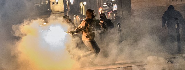 Homem lança um coquetel molotov contra policiais durante manifestaçãoem Nantes, oeste da França — Foto: LOIC VENANCE / AFP