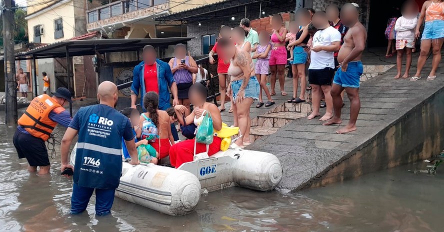 Moradores  que ficaram 'ilhados' são retirados de bote na Rua Guaiuba, em Acari