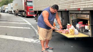 Caminhoneiro Gerson Fernandes aproveitou o trânsito parado na Serra das Araras para preparar o almoço — Foto: Márcia Foletto