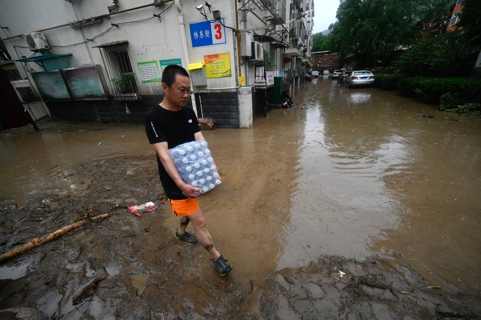 Homem caminha por uma rua inundada no distrito de Mentougou, em Pequim — Foto: Pedro Pardo / AFP