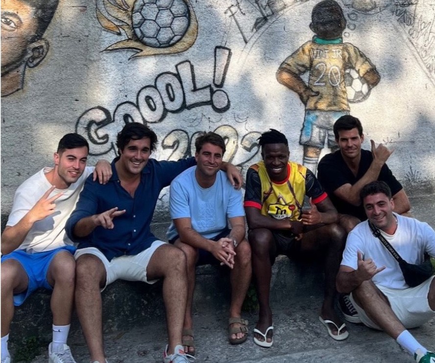 Amigos de Vini Jr. posam com o jogador na rua em que ele jogava bola, no Porto do Rosa, em São Gonçalo