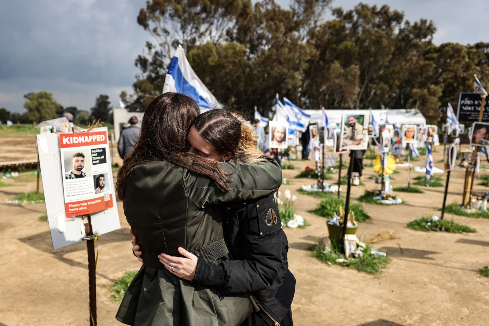 Duas mulheres reagem ao visitar o local do festival de música em  Kibutz Reim, sul de Israel, em 19 de fevereiro de 2024 — Foto: RONALDO SCHEMIDT/ AFP