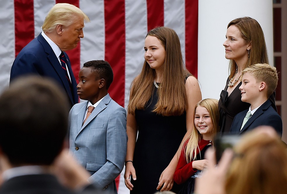 O então presidente Donald Trump se aproxima de Amy Coney Barrett e seus filhos durante evento no Rose Garden, em 2020. — Foto: Olivier Douliery/AFP