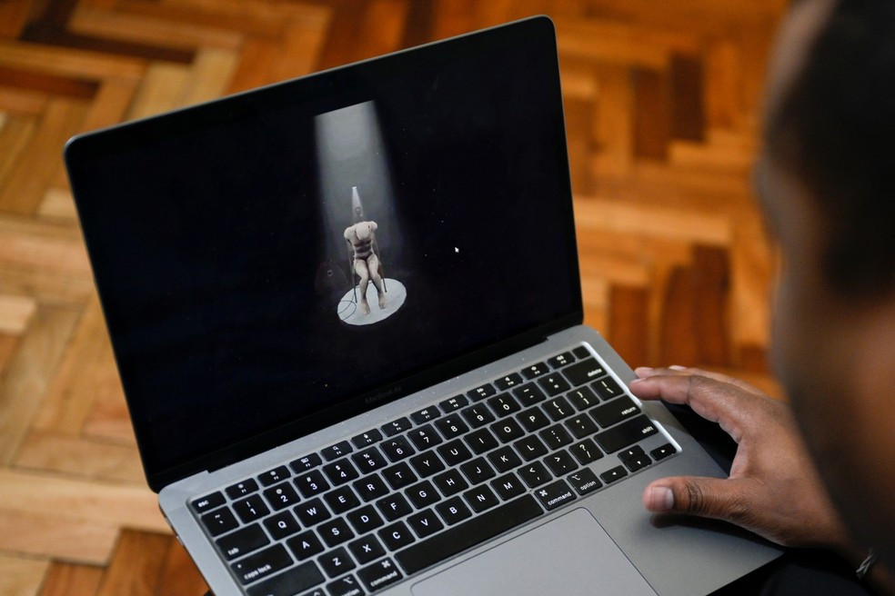 Victor Navarro, ex-preso político venezuelano e desenvolvedor do projeto "Helicoide Reality", mostra em seu notebook parte do passeio de realidade virtual do El Helicoide — Foto: Luis Robayo / AFP