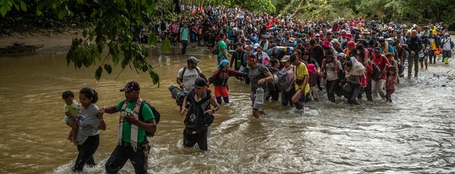 Migrantes entram num rio na região de DariŽn, na Colômbia — Foto: Federico Rios/The New York Times