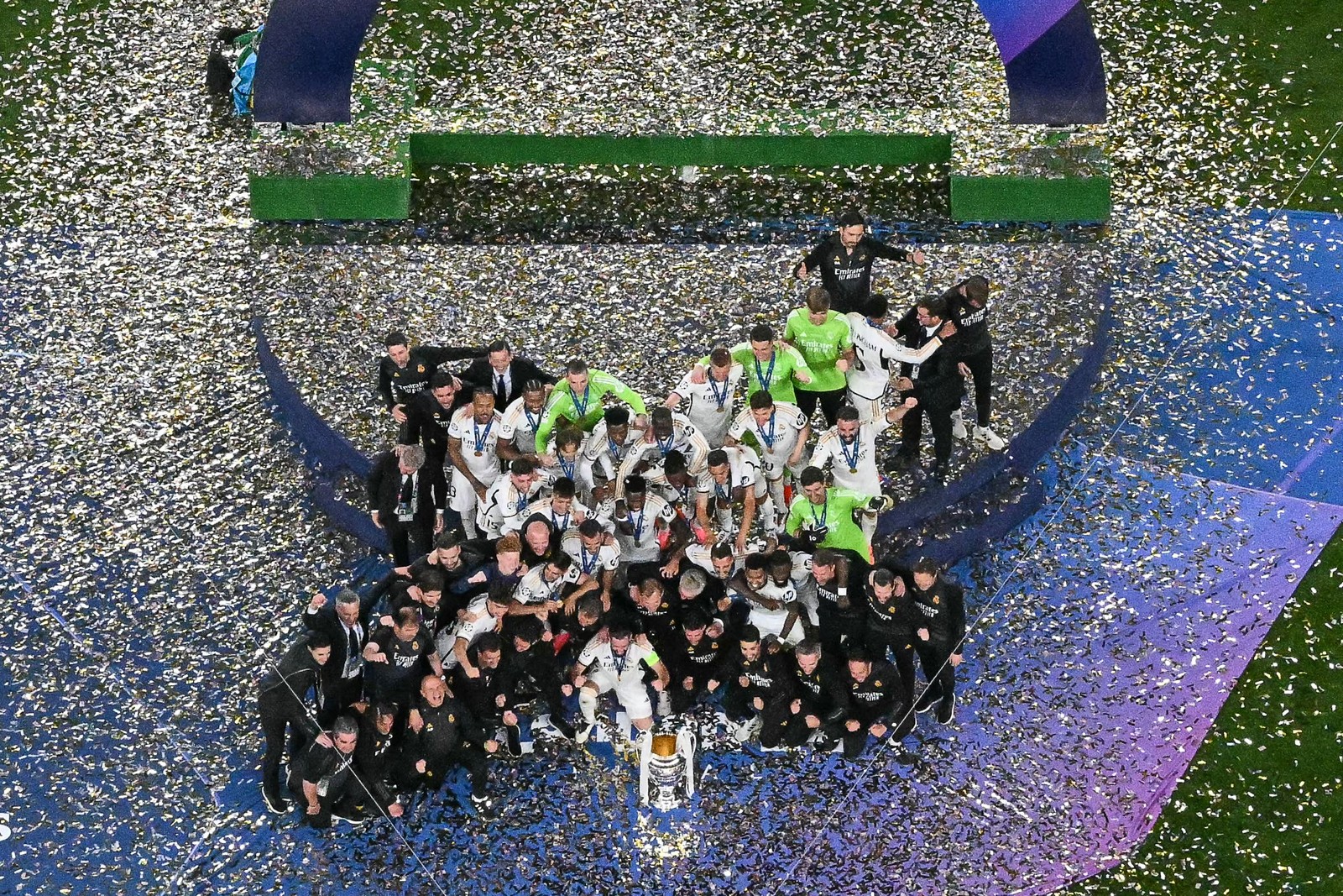 Os jogadores do Real Madrid comemoram a vitória com o troféu no pódio no final da final da UEFA Champions League entre Borussia Dortmund e Real Madrid, no estádio de Wembley, em Londres, no dia 1º de junho de 2024. — Foto: Ben Stansall /AFP