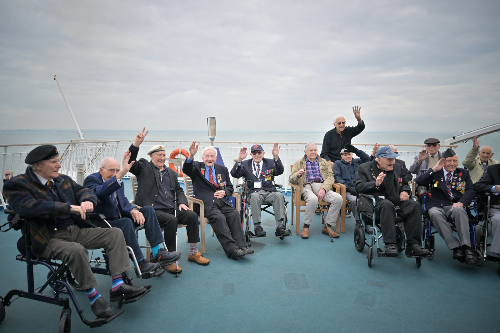 Veteranos do Reino Unido posam durante uma viagem à França na balsa Brittany Ferries, perto de Porthmouth, sul da Inglaterra, em 4 de junho de 2024, como parte das comemorações do "Dia D". — Foto: Lou BENOIST/AFP