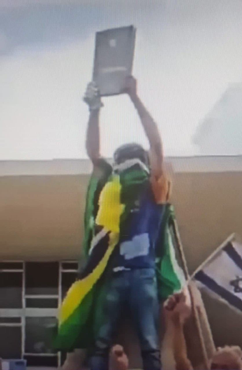 Manifestantes exibe cópia da Constituição roubada do STF — Foto: Reprodução