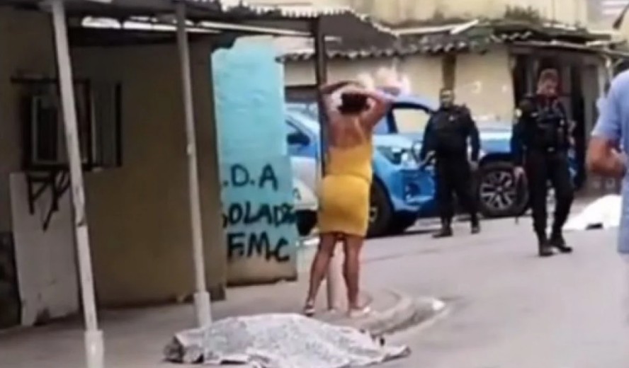 Uma mulher perto de um dos mortos durante o confronto no Fumacê