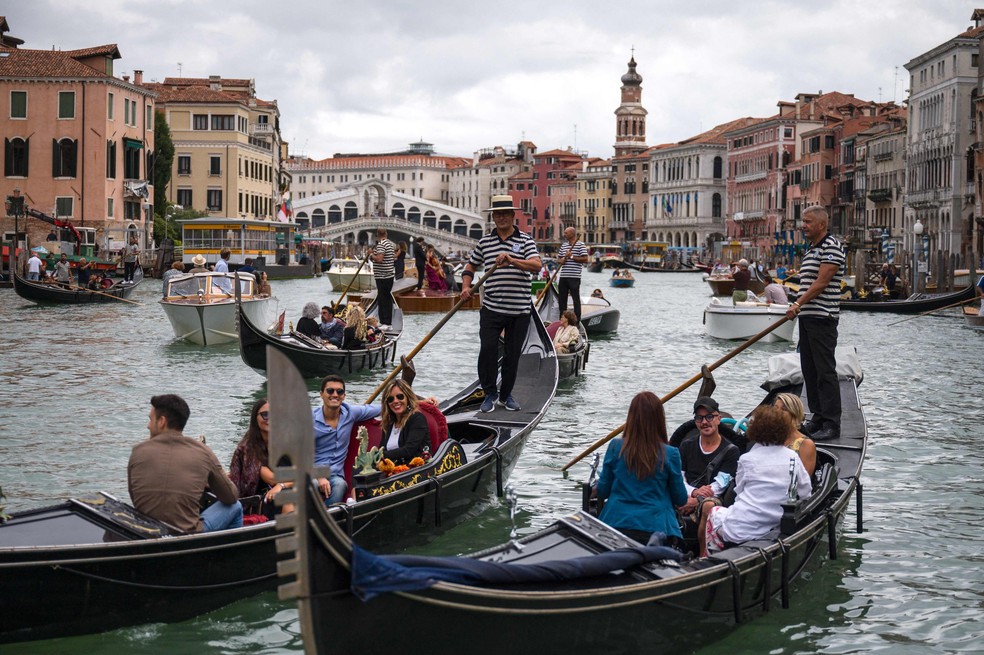 Turistas nas gôndolas de Veneza: cidade tem registrado movimento pré-pandemia — Foto: Marco Bertorello / AFP