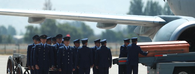 Membros da Força Aérea Chilena descarregam o caixão com o corpo do ex-presidente chileno Sebastián Piñera no Aeroporto de Pudahuel, em Santiago — Foto: Raul Bravo/AFP