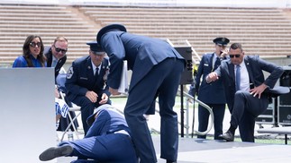 O político estava em um palco montado para o evento e se desequilibrou logo após cumprimentar um militar — Foto: Brendan Smialowski / AFP