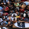 Palestinos recitam oração sobre o corpo do jornalista da al-Jazeera Ismail al-Ghoul, morto com o cinegrafista Rami al-Refee em um ataque israelense na Faixa de Gaza - Omar AL-QATTAA / AFP