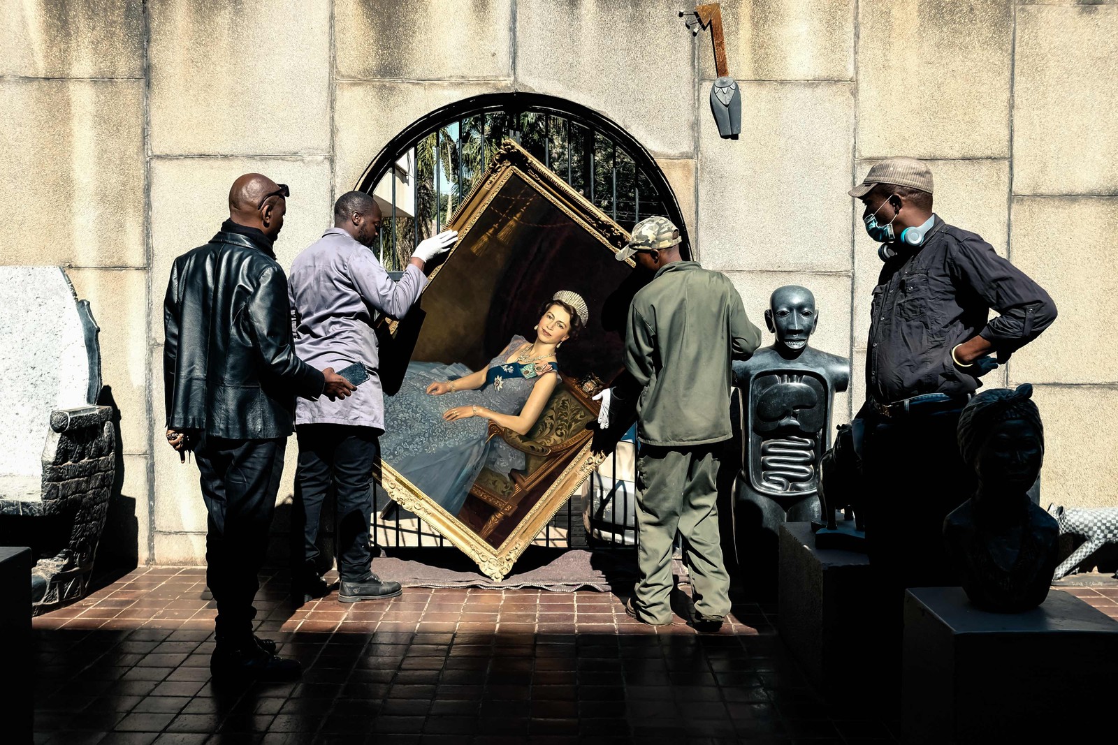 Trabalhadores montam um retrato da Rainha Elizabeth II na Galeria Nacional de Arte do Zimbábue, em Harare. — Foto: Jekesai NJIKIZANA / AFP