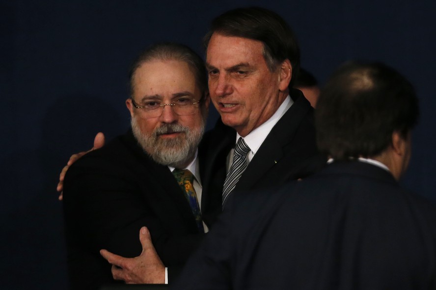 O então presidente Jair Bolsonaro abraça Augusto Aras durante sua cerimônia de posse como procurador-geral da República em 2019